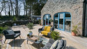 a patio with chairs and tables and a building at Ty Coets in Llanfairpwllgwyngyll