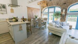 a kitchen and living room with a couch and a table at Ty Coets in Llanfairpwllgwyngyll