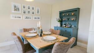 uma mesa de jantar com cadeiras e um armário azul em Ty Melyn em Beaumaris