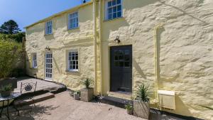 a stone house with a door and a patio at Ty Melyn in Beaumaris