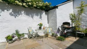 a patio with a table and chairs and plants at Ty Castell in Beaumaris