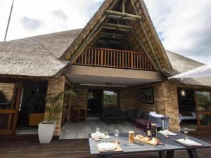 um pátio com um deque e uma mesa com copos de vinho em Kruger Park Lodge Unit 538 - PmP em Hazyview