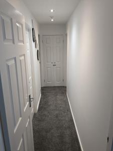 an empty hallway with white walls and a door at Jesmond heart stays in Hartlepool