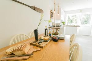 una mesa de madera con pan y botellas de vino. en Anchor Cottage, en Cemaes