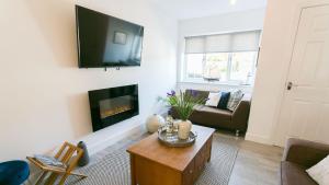 a living room with a fireplace and a couch at Anchor Cottage in Cemaes Bay