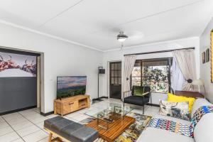 a living room with a couch and a tv at Sunninghill Spacious Executive Condo in Sandton