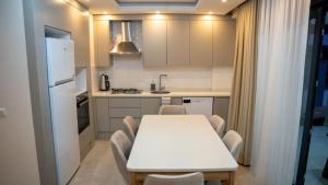 a small kitchen with a white table and chairs at AMY VILLAS in Antalya