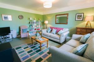 a living room with a couch and a table at Bears Cottage in Moelfre