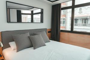 A bed or beds in a room at Poem Apartments, Las Canteras