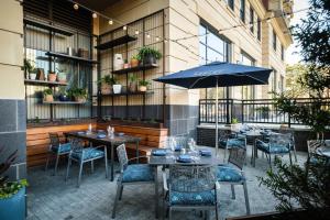 a patio with tables and chairs and an umbrella at Kimpton Aertson Hotel by IHG in Nashville