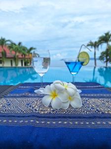 un tavolo con due bicchieri di vino e un fiore sopra di Seabreeze @ Koh Mak a Ko Mak