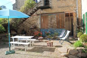 une terrasse avec une table, des chaises et un parasol dans l'établissement logement au sein d une abbaye cistercienne, à Saint-Martin-le-Vieil