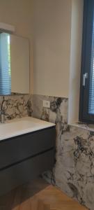 baño con lavabo y pared de mármol en La Morra 66, en La Morra