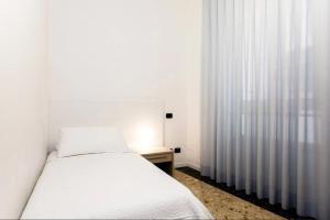 a white bedroom with a bed and a window at Residence Degli Aranci - by Casêta in Ancona