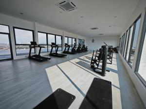 a gym with treadmills and ellipticals in a room with windows at Armani Soho Subang Jaya by Idealhub in Subang Jaya