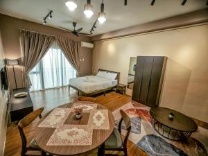 Cette chambre comprend un lit, une table et des chaises. dans l'établissement Armani Soho Subang Jaya by Idealhub, à Subang Jaya