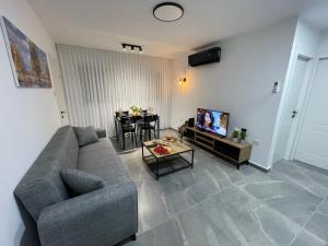 a living room with a couch and a table at דירת אירוח מפנקת בעיר אשקלון - 5 דקות נסיעה מהים in Ashqelon