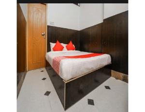 HOTEL SANDS INN, Jodhpur في جودبور: غرفة نوم عليها سرير ومخدات حمراء