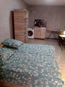 a bedroom with a bed and a kitchen with a stove at A cozy bedsit! in Tashkent