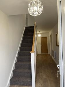 a staircase in a house with a chandelier at 4 bedroom House Boston Lincs Pet & Child friendly in Boston