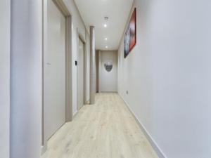 an empty hallway with white walls and wood floors at Luxury Unique 2bedroom city centre in Manchester