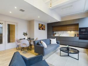 a living room with a blue couch and a table at Luxury Unique 2bedroom city centre in Manchester