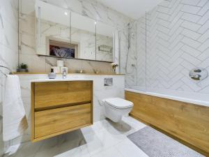 a bathroom with a tub and a toilet and a sink at Luxury Unique 2bedroom city centre in Manchester