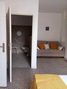 ein Wohnzimmer mit einem Sofa und einem Badezimmer in der Unterkunft Chambre d'hôtes PMR Hildegarde in Moissac