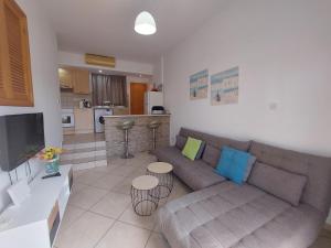 a living room with a couch and a kitchen at Palm Beach Apartment 26 in Limassol