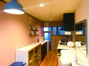 una pequeña cocina con fregadero y encimera en NOW TRAVEL ShinOsaka, en Osaka