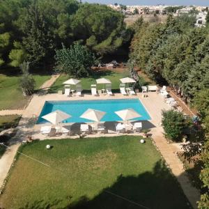 an overhead view of a swimming pool with chairs and umbrellas at Agriturismo Santa Chiara in Alezio
