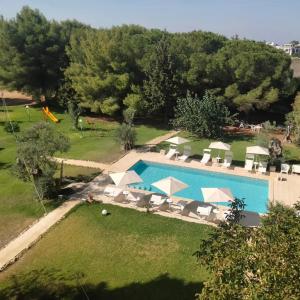 an aerial view of a pool with chairs and umbrellas at Agriturismo Santa Chiara in Alezio