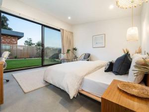 a bedroom with a large bed and a large window at LUXE Poolside living, in the heart of Flinders in Flinders +24 photos