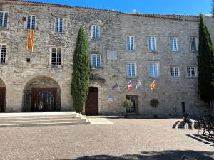 duży kamienny budynek z flagami przed nim w obiekcie L'OUSTAOU BELLO VISTO w mieście Le Castellet