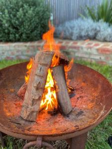 a fire pit with two logs on top of it at LUXE Poolside living, in the heart of Flinders in Flinders