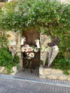 una mesa con flores frente a una puerta de madera en L'OUSTAOU BELLO VISTO, en Le Castellet