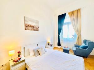 1 dormitorio con 1 cama blanca grande y 1 silla azul en Kerepesi City Apartment en Budapest