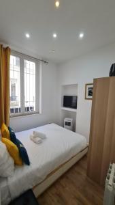Un dormitorio blanco con una cama grande y una ventana en 32 Atelier Paris Fashion, en París