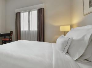 a bedroom with a white bed and a window at AC Hotel by Marriott Penang in Bayan Lepas