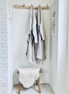 a coat rack with coats and a stool in a room at ELSK Cottage in Zandvoort