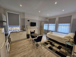 a bedroom with a bed and a kitchen with a fireplace at Studio flat in lovely Alexandra Palace London in London