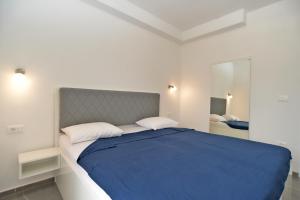 una camera da letto con un grande letto con una coperta blu di Apartments Djordjo 2295 a Banjole