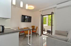 una cucina e un soggiorno con tavolo e sedie di Apartments Djordjo 2295 a Banjole
