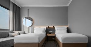 a hotel room with two beds and a couch at AC Hotel by Marriott Penang in Bayan Lepas