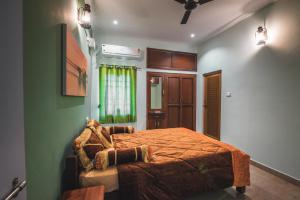 a bedroom with a bed and a green wall at Cheerful 2-bedroom near Auro Beach in Kālapettai