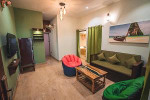 a living room with a couch and a table at Cheerful 2-bedroom near Auro Beach in Kālapettai