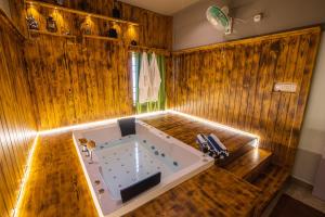 a jacuzzi tub in a room with wooden walls at Cheerful 2-bedroom near Auro Beach in Kālapettai