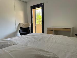 1 dormitorio con 1 cama, 1 silla y 1 ventana en Villa Aix Centre avec Piscine, en Aix-en-Provence