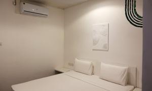 ein weißes Schlafzimmer mit einem Bett und einem Bild an der Wand in der Unterkunft City Beds Negombo in Negombo