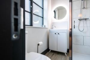 a bathroom with a sink and a toilet and a mirror at 2 Castle Mews in Salisbury